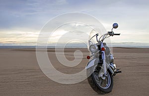Off-road motorcycle standing still in the open desert beneath heavy clouds