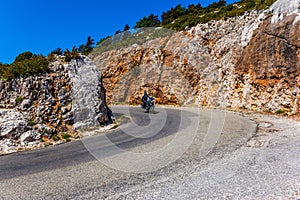 A lone motorcyclist on a mountain road