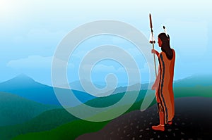 A lone native american warrior with a spear stands on a high mountain and looks into the distance.