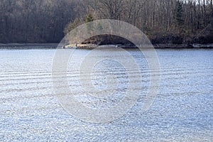 Lone person and a boat across a Autumn lake