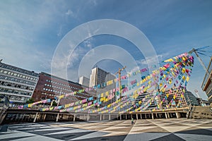 Lone person in empty city square full of small colourful flags hanging alone in the sky is empty because of the covid 19, covid19 photo