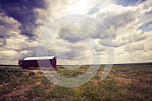 Lone red hangar, barn in prairie