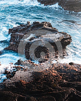 A lone rock in the middle of the Hawaii coast.