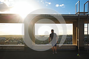 Lone roofer on roof at sunset