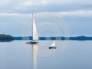 A lone sailboat gliding across the calm waters of a lake.