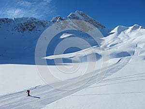 Lone skier on ski piste on sunny winter day photo