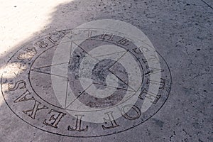 Lone Star of Texas Silver emblem on sidewalk concrete