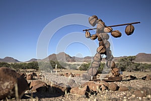 Lone stone man of Kaokoland walking to a gathering at Marble. Kunene Region, Namibia. low angle of the statue.