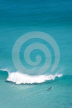 Lone surfer in vast ocean