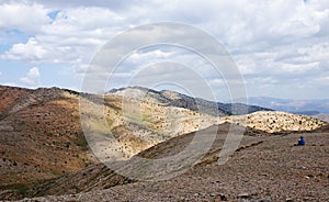 Lone tourist sits in the mountains and reflects on