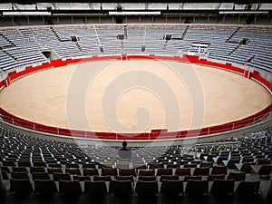 Lone visitor sitting in empty bullfighting arena in Spain. Spanish corrida, traditional cultural event. Animal abuse, cruelty to