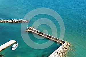 A lone white boat moored at the sea on a Sunny day. Pier with access to the blue sea