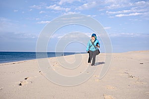 Lone woman hiker on Race Point beach, walks alone in the sand on Cape Cod National Seashore in Provincetown