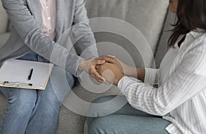 Loneliness, despair and depression concept. Professional psychologist touching female patient hands