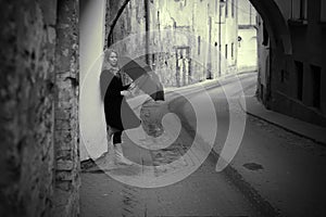 Lonelly woman with umbrella in a street, retro