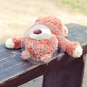 Lonely abandoned on the wooden bench lonely teddy bear toy