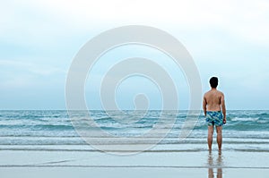 A lonely Asian man stand alone on beach