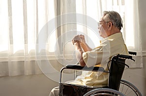 Lonely Asian Senior man was sick and sitting on wheelchair. Retirement age lifestyle and stay at home