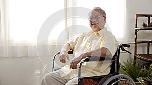 Lonely Asian Senior man was sick and sitting on wheelchair. Retirement age lifestyle and stay at home