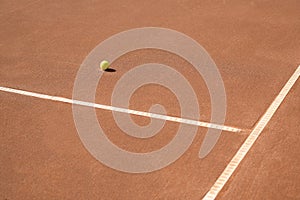 Lonely ball near the lines on a clay tennis court