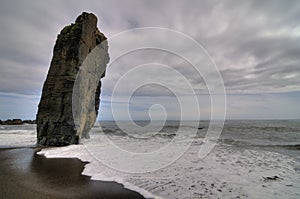 Lonely beach with a big inclined rock