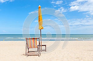 Lonely beach chair and sun umbrella on beautiful beach.