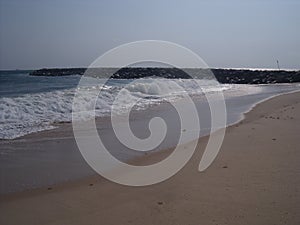 Lonely Beach with Flowing Water guided by white stones.