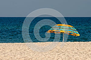 Lonely beach umbrella on a deserted sea beach