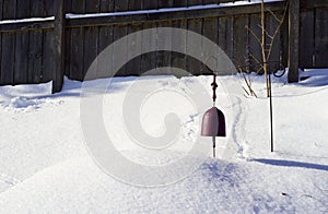 Lonely bell silenced in winter snow