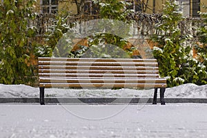 Lonely bench covered with snow at night