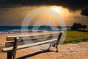 A lonely bench by the sea at sunset on the island Crete