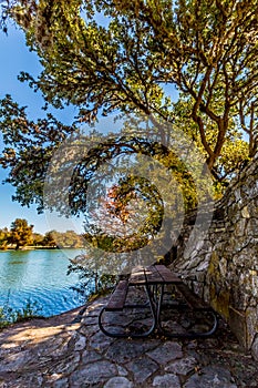 Lonely Bench at a Waterside under the Shade of Trees in Fall