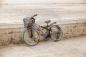 Lonely bicycle standing on concrete pier.