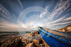 lonely boat ashore against a dramatic sky