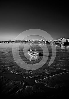 Lonely boat on receding shore