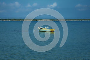 Lonely Boat at sea with cloudy sky in the background.