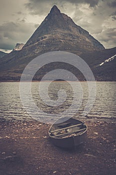 Lonely boat on the shore of wild mountain lake, Innerdalen