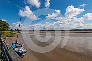 A lonely boat sits on the river Mersey waiting for the tide to come back