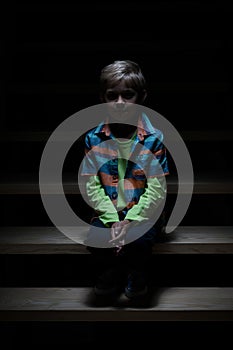 Lonely boy sitting on staircase