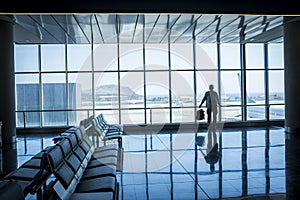 Lonely business man travel and wait at the airport gate - concept of delay and cancel filght problem and passenger rights - people