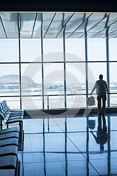 Lonely business man travel and wait at the airport gate - concept of delay and cancel filght problem and passenger rights - people