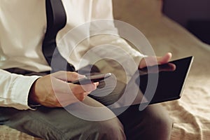 Lonely businessman in hotel room sitting on the bed