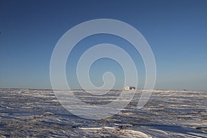 Lonely cabin along an arctic landscape with snow on the ground