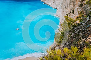 Lonely catamaran yacht in blue bay of Navagio beach. Azure turquoise sea water pattern near paradise sandy beach. Famous