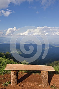 Lonely chair with grass, mountain and cloudy sky view of Chiangmai Thailand