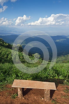 Lonely chair with grass, mountain and cloudy sky view of Chiangmai Thailand