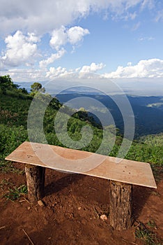 Lonely chair with grass, mountain and cloudy sky view of Chiangmai Thailand