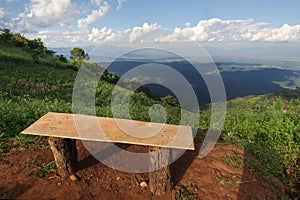 Lonely chair with grass, mountain and cloudy sky view of Chiangmai Thailand