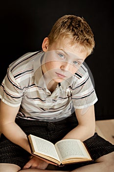 Lonely child sitting and reading a book