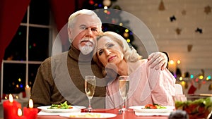 Lonely childless elderly couple celebrating Christmas, husband hugging wife